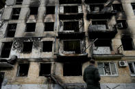 A man stands in front of a damage building ruined by attacks in Hostomel, outskirts Kyiv, Ukraine, Thursday, May 26, 2022. (AP Photo/Natacha Pisarenko)