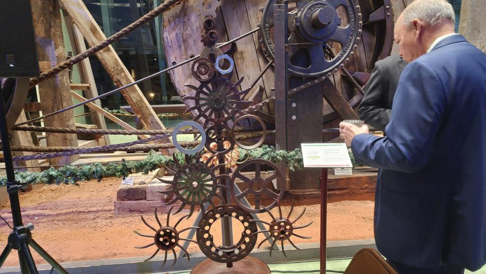 A prospective bidder looks over A Christmas tree made out of scrap iron Thursday night at the 2nd annual Tidings of the Trees fundraiser event at the Panhandle-Plains Historical Museum in Canyon.