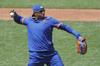 New York Mets left fielder Yoenis Cespedes stretches out to throw the ball as he waits for his turn in the batting cage during the afternoon session of a summer baseball training camp workout at Citi Field, Thursday, July 9, 2020, in New York. (AP Photo/Kathy Willens)