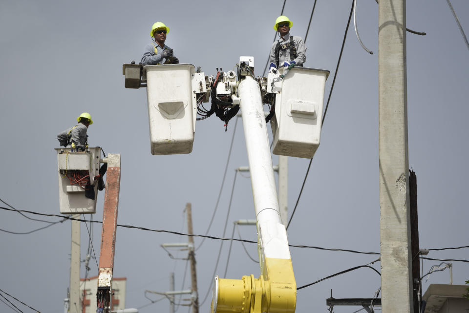 FILE - Puerto Rico Electric Power Authority workers repair distribution lines damaged by Hurricane Maria in the Cantera community of San Juan, Puerto Rico, on Oct. 19, 2017. Five years after Maria slammed into Puerto Rico and exposed the funding problems the Caribbean island has long faced, philanthropists warn that many of those issues remain unaddressed, just like the repairs still needed for the American territory’s physical infrastructure. (AP Photo/Carlos Giusti, File)