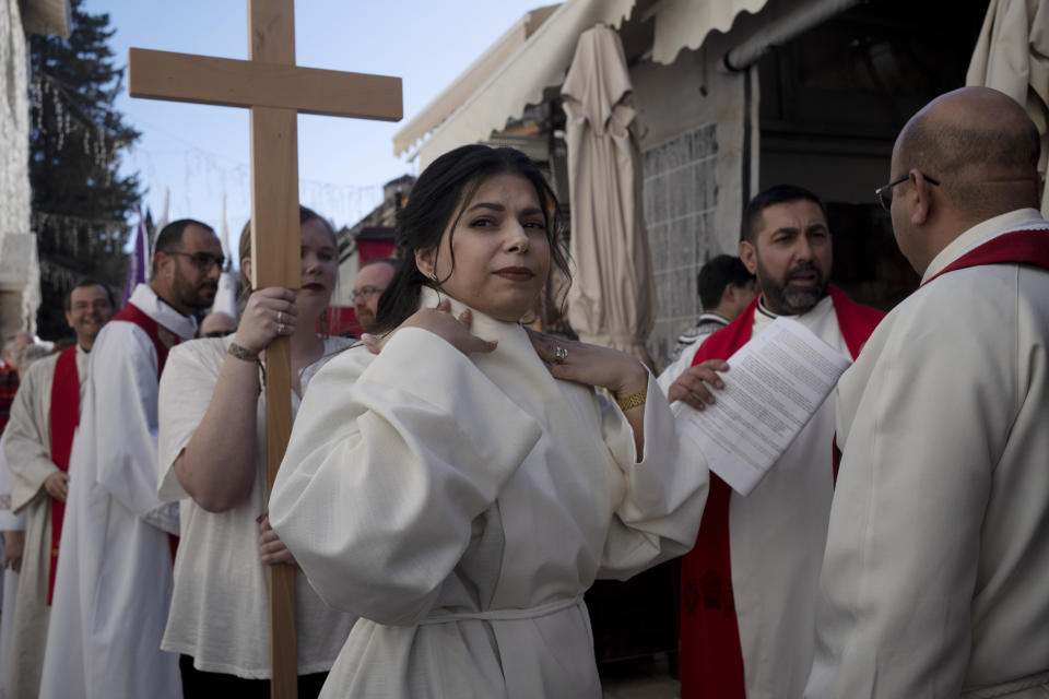 Sally Ibrahim Azar, center, a Palestinian Christian and Council member of the Lutheran World Federation checks her collar before the procession for her ordination as the first female pastor in the Holy Land, in the Old City of Jerusalem, Sunday, Jan. 22, 2023. (AP Photo/Maya Alleruzzo)