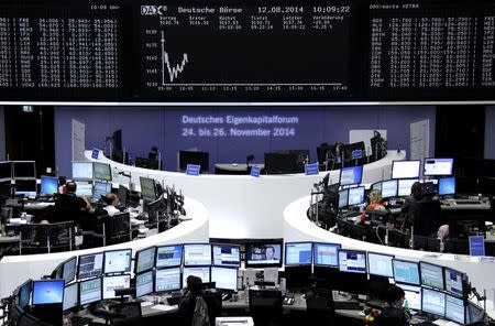Traders are pictured at their desks in front of the DAX board at the Frankfurt stock exchange August 12, 2014. REUTERS/Remote