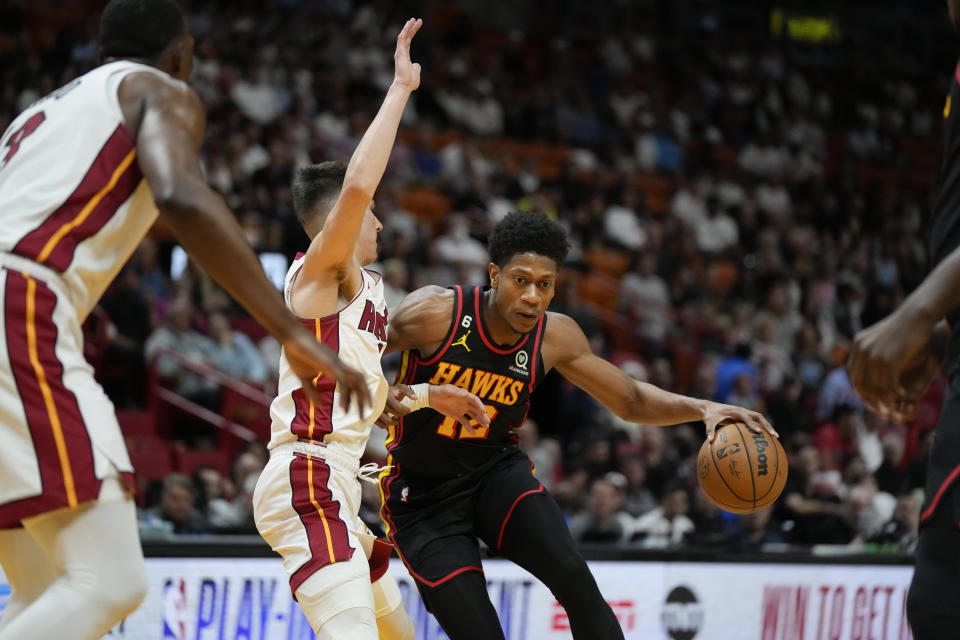 Atlanta Hawks forward De'Andre Hunter (12) is defended by Miami Heat guard Tyler Herro during the first half of an NBA basketball play-in tournament game Tuesday, April 11, 2023, in Miami. (AP Photo/Rebecca Blackwell)