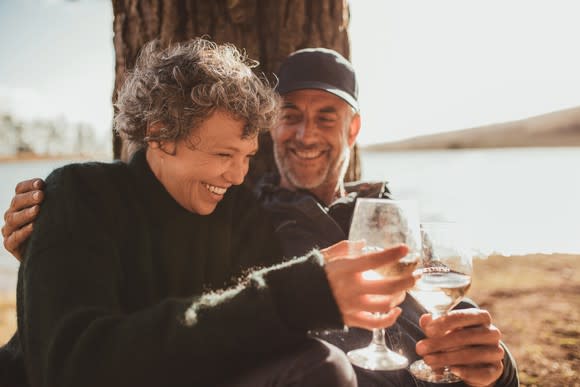 An older couple enjoying a glass of wine outside