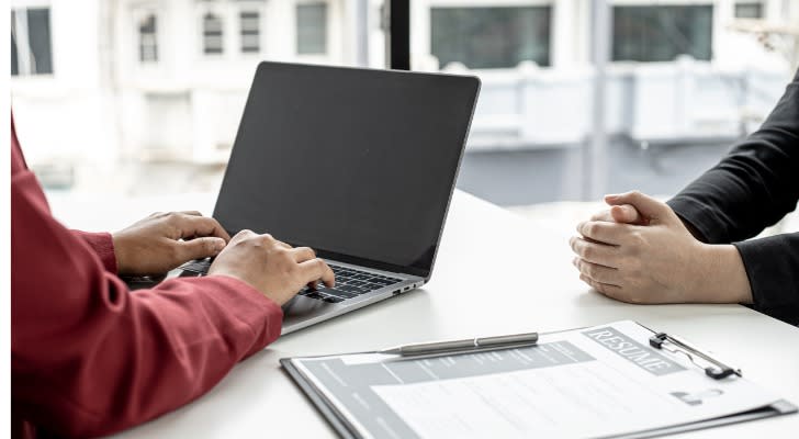 An employer reviewing the qualifications of a candidate after reviewing his cover letter.