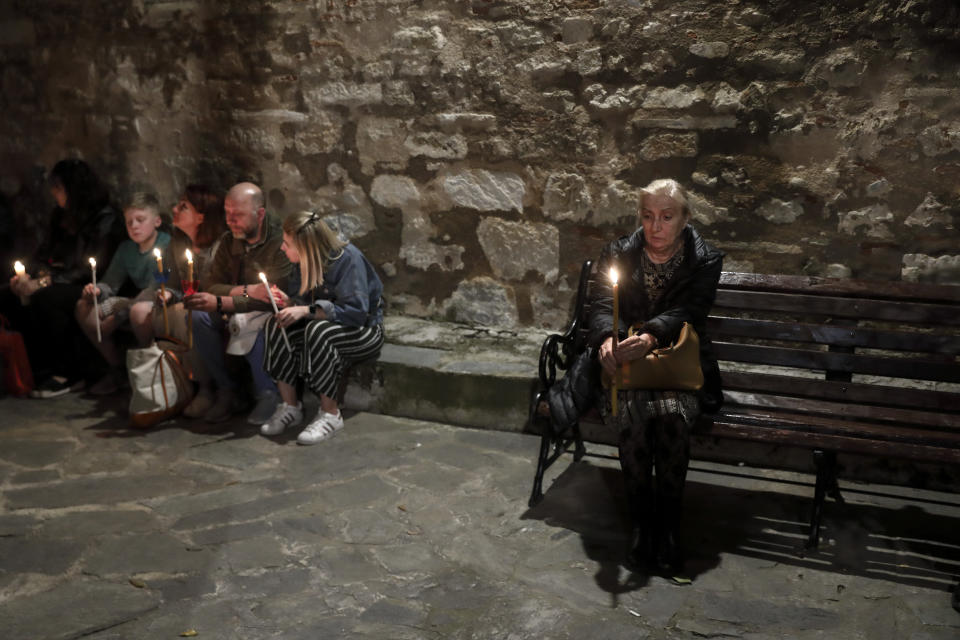 Orthodox faithful hold candles with the "Holy Fire" brought from Jerusalem, outside a church in Athens, on Saturday, April 27, 2019. A lantern carrying a flame lit in Jerusalem's Holy Sepulcher Church was welcomed in Greece with honors reserved for visiting heads of state. But a senior cleric boycotted the ceremony, miffed that the "Holy Flame" did not land within his see.(AP Photo/Yorgos Karahalis)