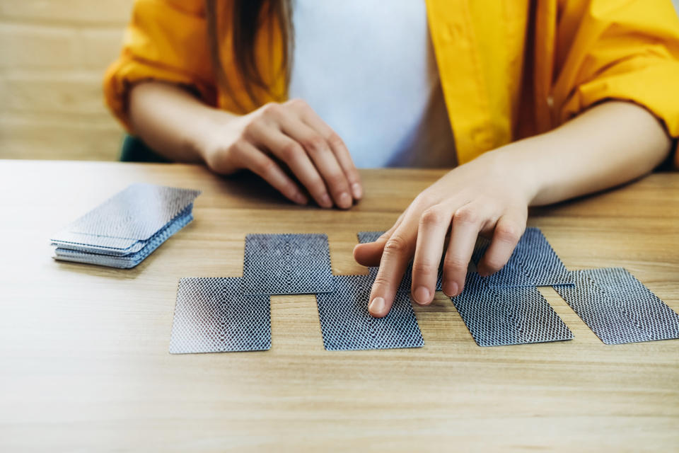 Person playing a matching game with cards on a wooden table