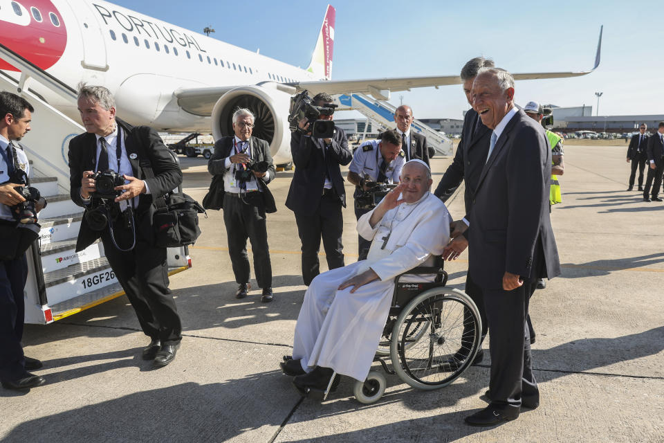 Pope Francis on a wheelchair is seen off by Portuguese President Marcelo Rebelo de Sousa, right, as he boards his flight to The Vatican from the Figo Madero air base near Lisbon, Sunday, Aug. 6, 2023, where he presided over the 37th World Youth Day. Francis told young people on Sunday the Catholic Church needs them and urged them to follow their dreams as he wrapped up World Youth Day in Portugal with a massive open-air Mass and an announcement that the next edition would be held in Asia for the first time in three decades. (Tiago Petinga/Pool via AP)