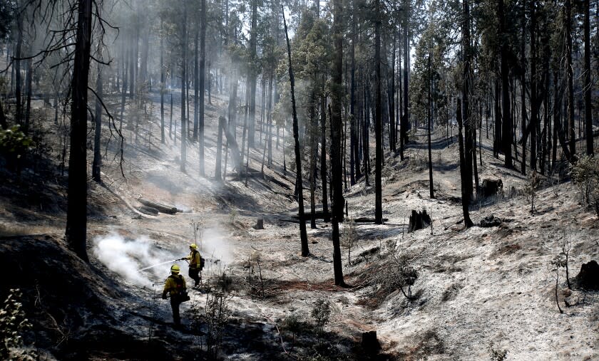 MARIPOSA, CALIF. - JULY 27, 2022. Firefighters put out hotspots in a moonscape created by the Oak fire near Mariposa on Wednesday, July 27, 2022. (Luis Sinco / Los Angeles Times)