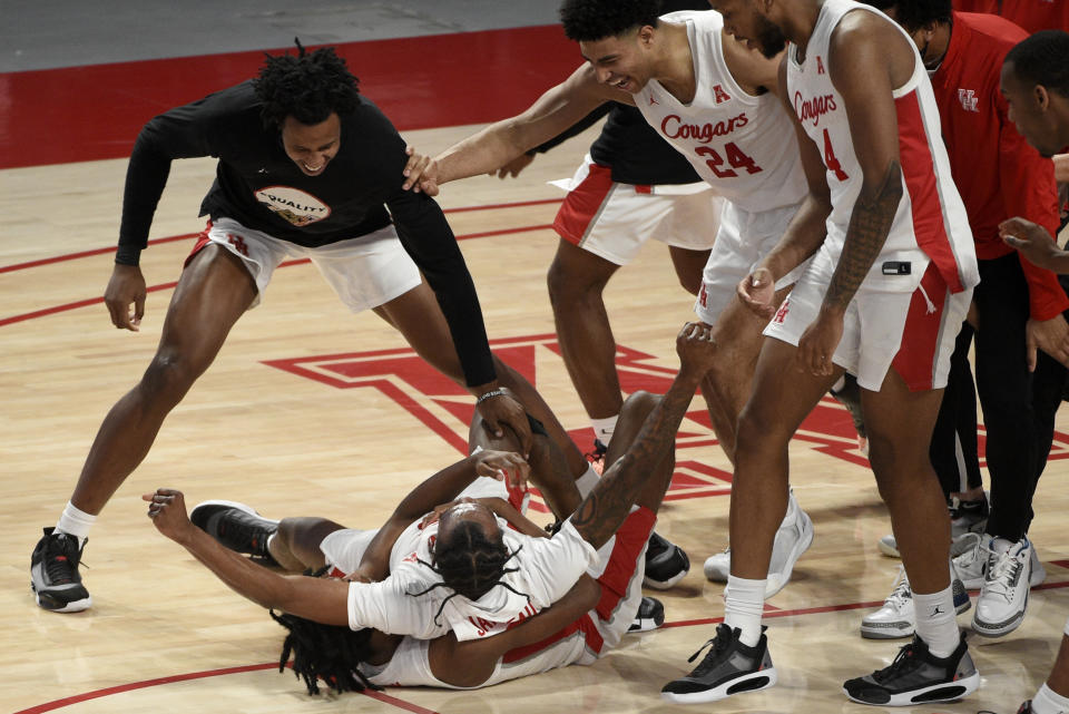 Houston guard Tramon Mark, bottom, celebrates his game-winning 3-point basket with teammates during the second half of an NCAA college basketball game against Memphis, Sunday, March 7, 2021, in Houston. (AP Photo/Eric Christian Smith)