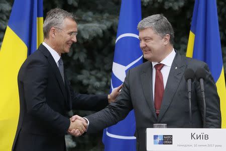 NATO Secretary General Jens Stoltenberg and Ukrainian President Petro Poroshenko shake hands during a joint news conference following a meeting of the NATO-Ukraine Commission in Kiev, Ukraine, July 10, 2017. REUTERS/Valentyn Ogirenko