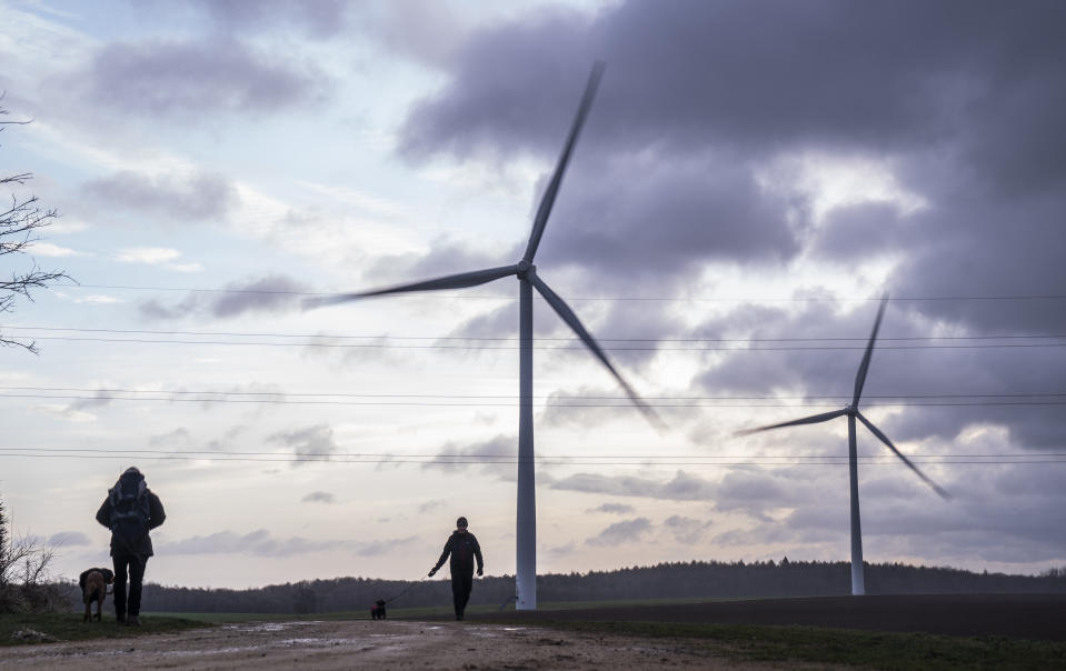 People walk their dogs at Hook Moor Wind Farm, near Leeds during Storm Pia, which is expected to cause disruption in parts of Scotland, the north of England and Northern Ireland. Picture date: Thursday December 21, 2023. (Photo by Danny Lawson/PA Images via Getty Images)