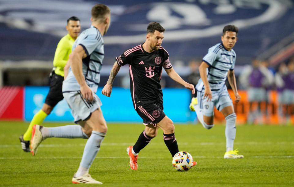 Apr 13, 2024; Kansas City, Kansas, USA; Inter Miami CF forward Lionel Messi (10) dribbles between Sporting Kansas City defenders during the second half at GEHA Field at Arrowhead Stadium. Mandatory Credit: Jay Biggerstaff-USA TODAY Sports