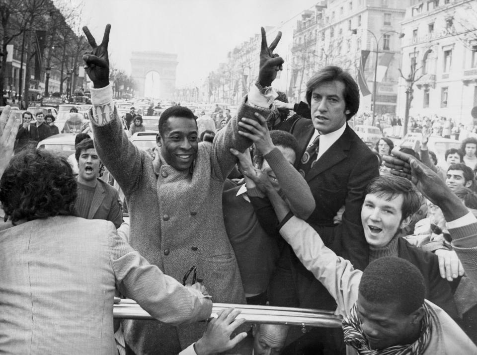 ARCHIVO - En esta foto del 30 de marzo de 1971, Pelé hace la señal del triunfo al pasear por los Campos Elíseos de París. (AP Foto/Levy, archivo)