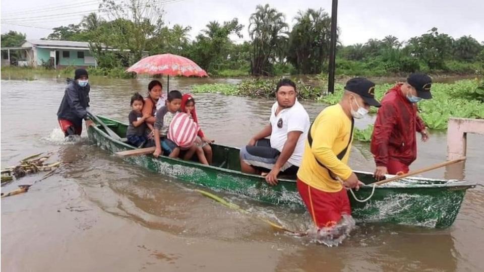 Los bomberos hondureños tuvieron que evacuar a familias en Tela tras la subida del río Lancetilla provocada por las lluvias.