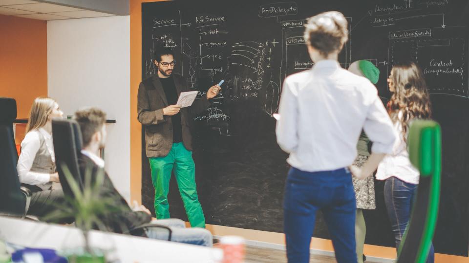 Young computer programmers are discussing a technical design.