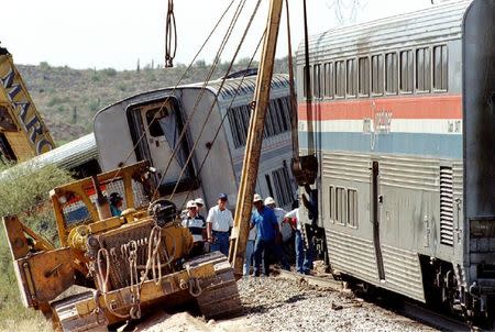 A crane helps put one of the passenger cars from a crashed Amtrak Sunset Limited back on the track near Hyder, Arizona, 60 miles west of Phoenix in this October 11, 1995 file photo as FBI and Southern Pacific investigators watch. REUTERS/Stringer/Files