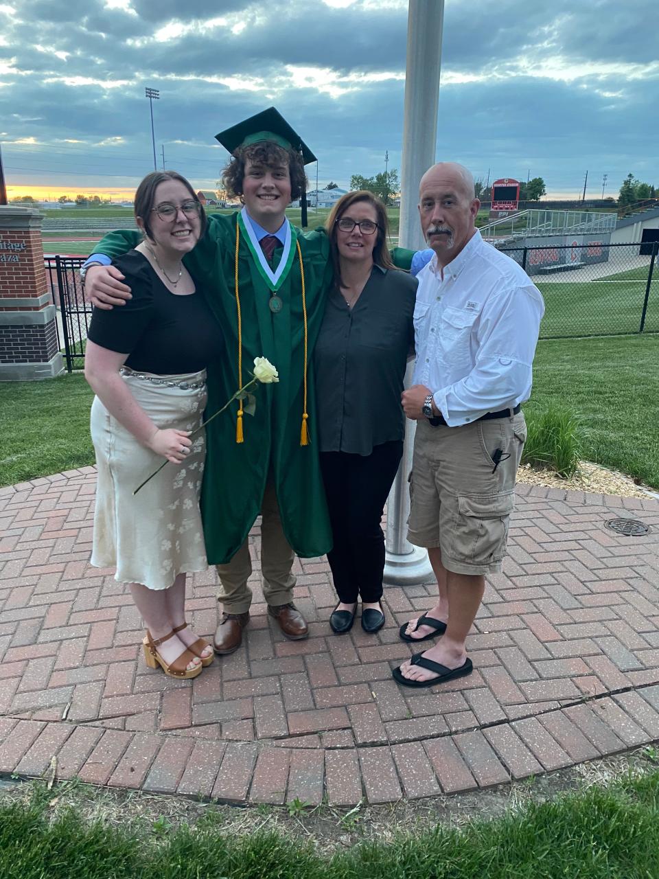 JT poses with his sister Harley, mother Stacy and father Todd at his high school graduation.
