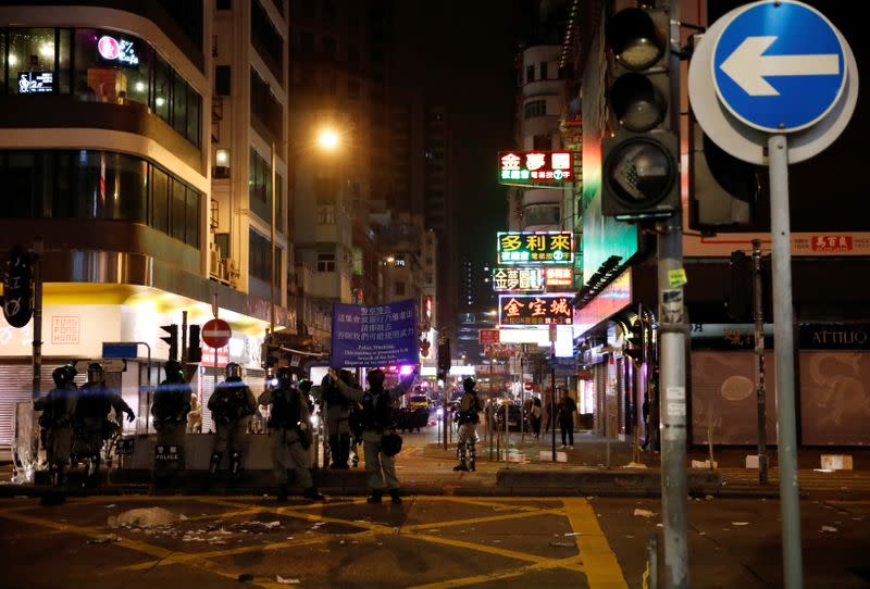 Riot police show a warning flag before firing a tear gas towards the anti-government demonstrators at Mong Kok in Hong Kong