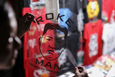 A man selling t-shirts with the image of North Korean leader Kim Jong Un displays a design ahead of the North Korea–United States Hanoi Summit in Hanoi, Vietnam February 21, 2019. REUTERS/Jorge Silva