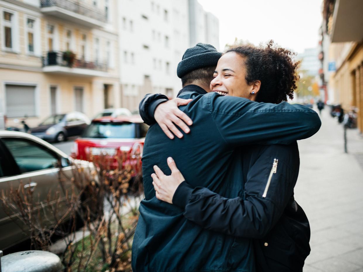 two people hugging on the street