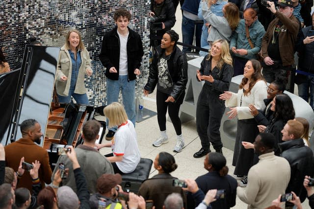 Members of the public watch a performance by the Mark de Lisser singers of Abba hit Waterloo on Saturday at Waterloo station in London (Alastair Grant/PA)