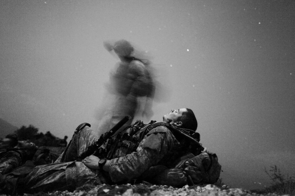 A U.S. soldier of 2-12 Infantry 4BCT-4ID Task Force Mountain Warrior takes a break during a night mission near Honaker Miracle camp at the Pesh valley of Kunar Province, Afghanistan, August 12, 2009. (Carlos Barria/Reuters)