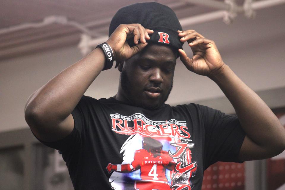 Raines defensive tackle Jyon Simon pulls on a Rutgers hat during his college football commitment on Thursday night.