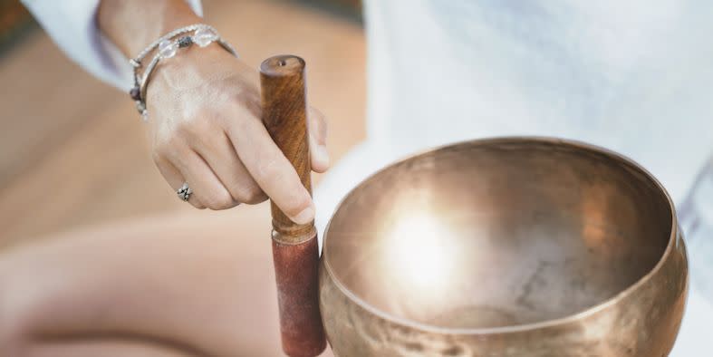 a woman holding a tibetan singing bowl in sound therapy