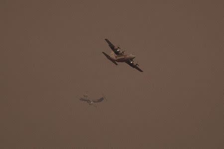 Firefighting aircraft circle over King Fire in El Dorado National Forest northeast of Sacramento, California September 20, 2014. REUTERS/Stephen Lam