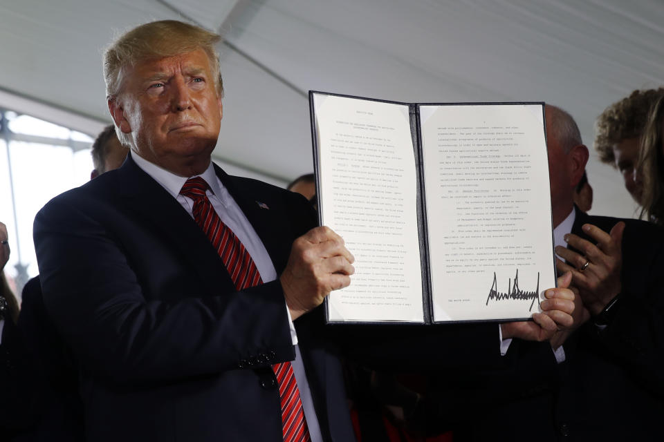 President Donald Trump holds up a signed executive order to streamline the approval process for GMO crops, after speaking at Southwest Iowa Renewable Energy in Council Bluffs, Iowa, Tuesday, June 11, 2019. (AP Photo/Patrick Semansky)