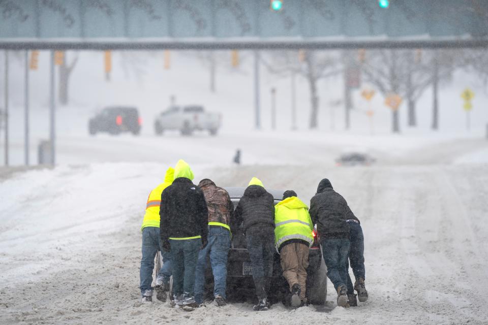 Good Samaritans help a driver out after his rear-wheel drive vehicle got stranded on Rosa L. Parks Blvd. after a winter storm in Nashville, Tenn., Monday, Jan. 15, 2024. (Denny Simmons/The Tennessean via AP) ORG XMIT: TNNAT604