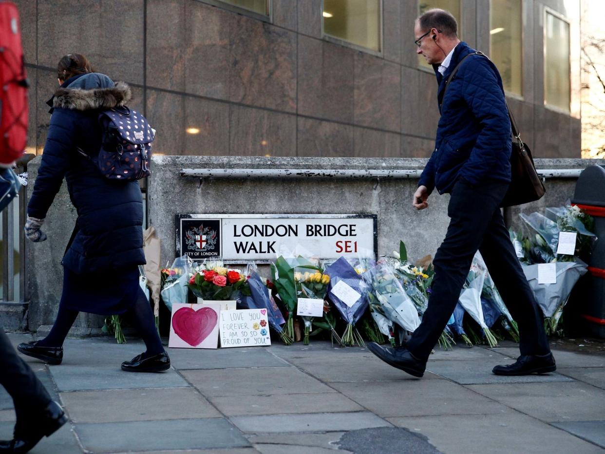 A commuter looks at flowers and signs left at the scene of the attack on London Bridge: Reuters