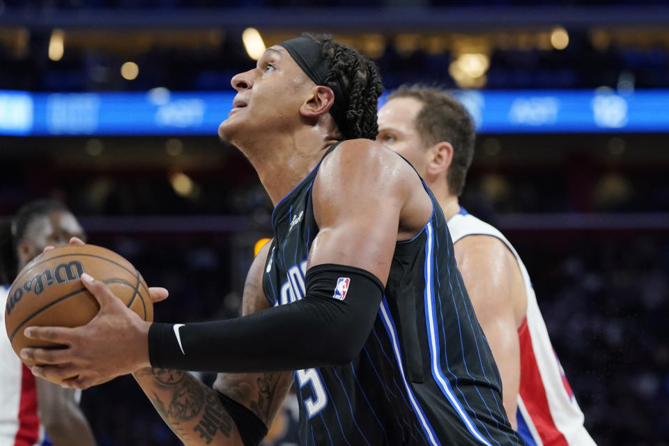 Orlando Magic forward Paolo Banchero (5) drives to the basket as Detroit Pistons forward Bojan Bogdanovic defends during the second half of an NBA basketball game, Wednesday, Oct. 19, 2022, in Detroit. (AP Photo/Carlos Osorio)