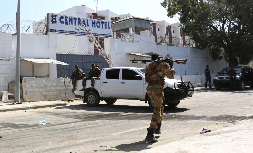 A Somali government soldier walks outside the Central Hotel after a suicide attack in Mogadishu