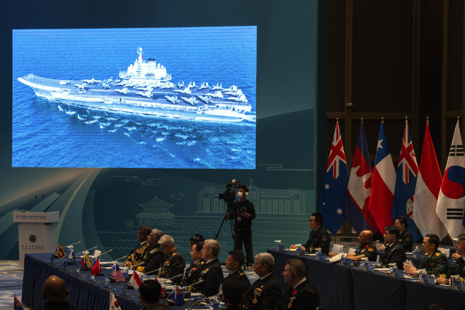 A screen shows a Chinese aircraft carrier at the opening of the Western Pacific Navy Symposium in Qingdao, eastern China's Shandong province on Monday, April 22, 2024. Zhang Youxia, one of China's top military leaders took a harsh line on regional territorial disputes, telling an international naval gathering in northeastern China on Monday that the country would strike back with force if its interests came under threat. (AP Photo/Ng Han Guan)