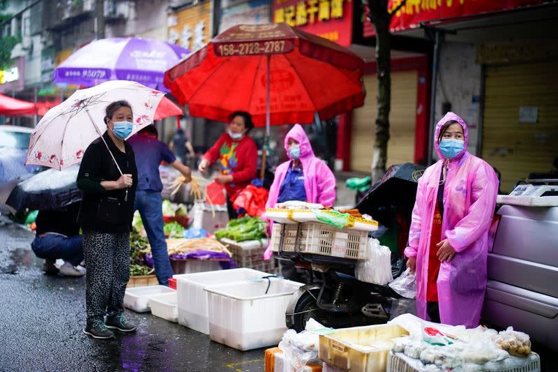 Imagen de archivo de varias personas con mascarillas en un mercado callejero en Wuhan, China.