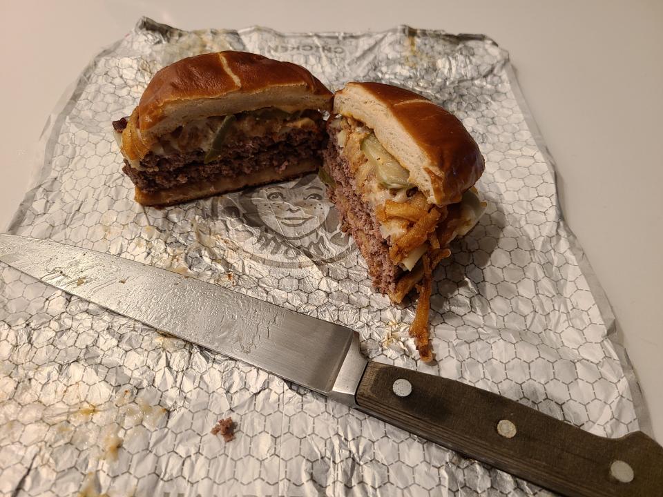 wendys pretzel bacon pub double cheeseburger cut it half with knife beside it on white wrapper