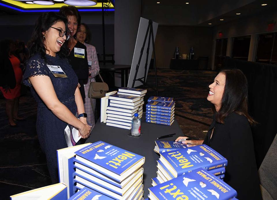 Author Joanne Lipman (r.) signs books for attendees of the WICT Network Leadership Conference at Manhattan’s Marriott Marquis.