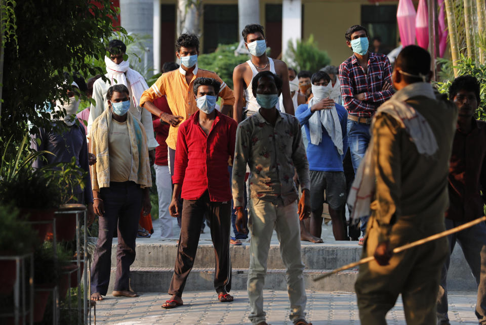 In this Wednesday, April 29, 2020, photo, Indian laborers kept in quarantine after arriving from outside the state protest against poor treatment at the quarantine center in Prayagraj, India. Tens of thousands of impoverished migrant workers are on the move across India, walking on highways and railway tracks or riding trucks, buses and crowded trains in blazing heat. They say they have been forced to leave cities and towns where they had toiled for years building homes and roads after they were abandoned by their employers _ casualties of lockdown to stop the virus from spreading. (AP Photo/Rajesh Kumar Singh)