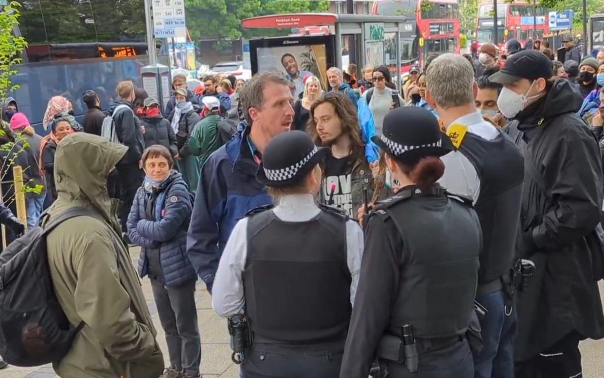 Police speaking with protesters, some of whom are masked