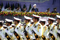 ADDS THAT ATTACK WAS ON A DIFFERENT MILITARY PARADE IN THE SOUTHWESTERN CITY OF AHVAZ - Iran's President Hassan Rouhani, top center, reviews army troops marching during the 38th anniversary of Iraq's 1980 invasion of Iran, in front of the shrine of the late revolutionary founder, Ayatollah Khomeini, outside Tehran, Iran, Saturday, Sept. 22, 2018. Elsewhere gunmen disguised as soldiers attacked the annual parade in the southwestern city of Ahvaz, killing dozens of people and wounding others in the bloodiest assault to strike the country in recent years. (AP Photo/Ebrahim Noroozi)