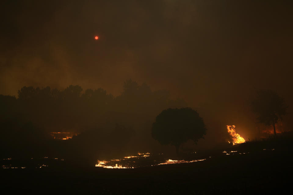 The sun is obscured as smoke darkens the sky in the village of Bemposta, near Ansiao, central Portugal, Wednesday, July 13, 2022. Thousands of firefighters in Portugal continue to battle fires all over the country that forced the evacuation of dozens of people from their homes. (AP Photo/Armando Franca)