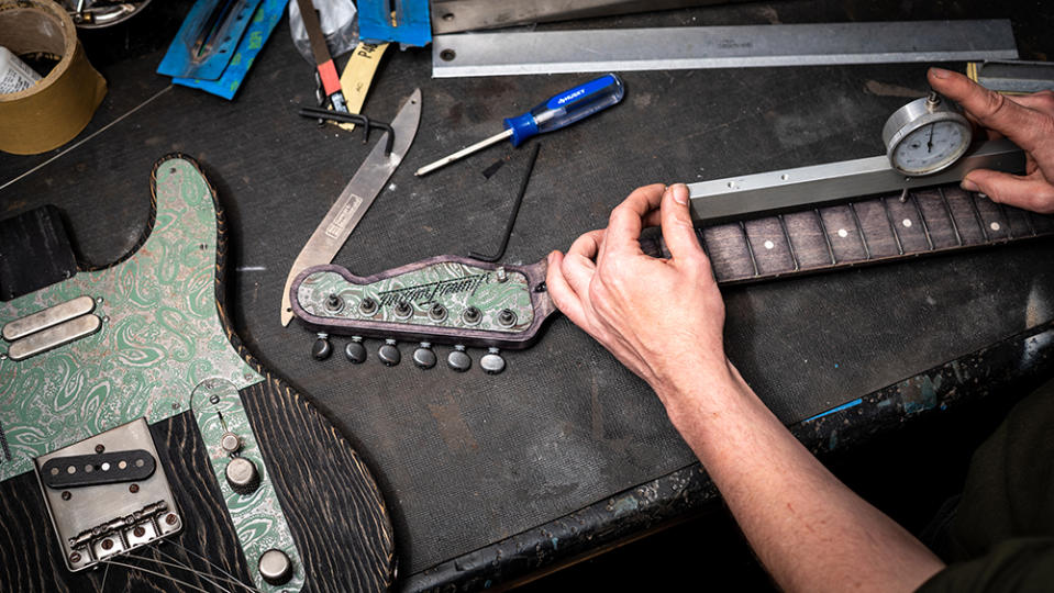 Assembling neck and body of a James Trussart's "Sage Green Antique Silver Paisley SteelGuardCaster" guitar in his workshop in Echo Park, Los Angeles.