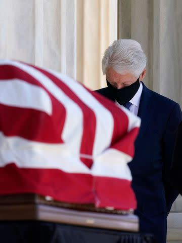 <p>ALEX BRANDON/POOL/AFP via Getty</p> Former President Bill Clinton pays his respects as Justice Ruth Bader Ginsburg lies in repose in front of the U.S. Supreme Court on Sept. 23, 2020