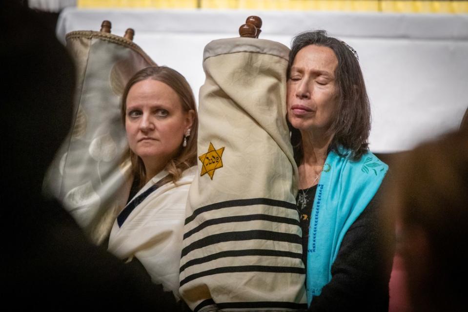 Susan Levy (right) closes her eyes as she carries one of the precious scrolls Sunday. N.Y.Post/Chad Rachman