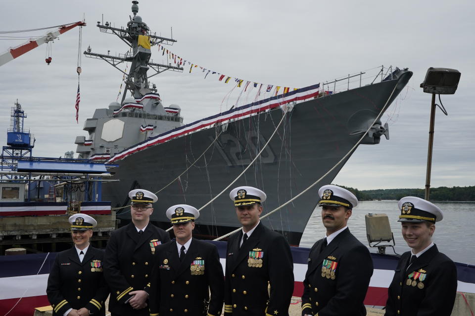 Naval officers pose in front of a warship named for Sen. Carl M. Levin, D-Michigan, Saturday, Oct. 2, 2021, at Bath Iron Works in Bath, Maine. The Arleigh Burke class destroyer was christened on Saturday. (AP Photo/Robert F. Bukaty)