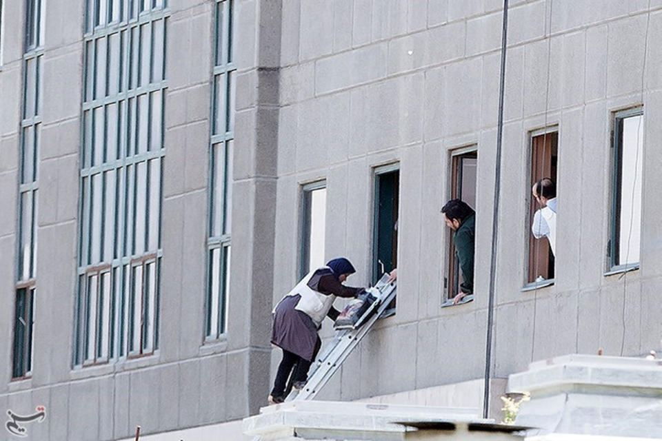 <p>A woman is evacuated during an attack on the Iranian parliament in central Tehran, Iran, June 7, 2017. (Photo: Tasnim News Agency/Handout via Reuters) </p>