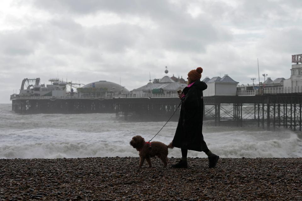 A woman walks her dog as Storm Ciaran brings high winds and heavy rain along the south coast of England, in Brighton, (Copyright 2023 The Associated Press. All rights reserved)