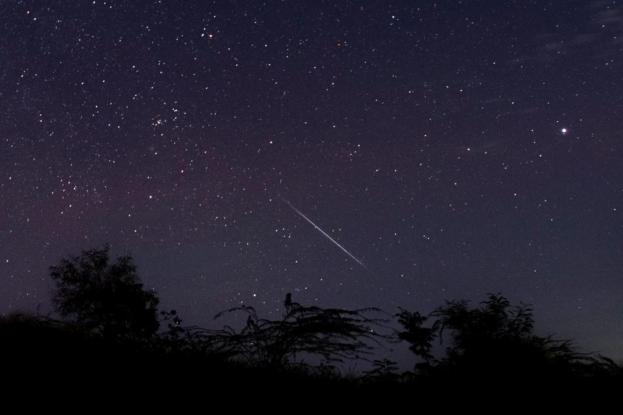 This photo taken in December 2018 with a long time exposure shows a meteor streaking through the night sky over Myanmar during the Geminid meteor shower.